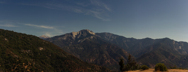 Panorama of tops of mountains in California against blue sky with stone shields at autumn, usa