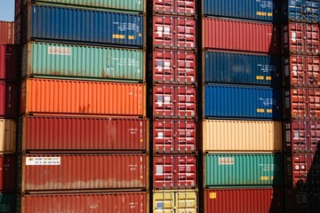 Fototapeta premium Stack of Cargo Containers at the docks at sunset for Logistic Import Export background