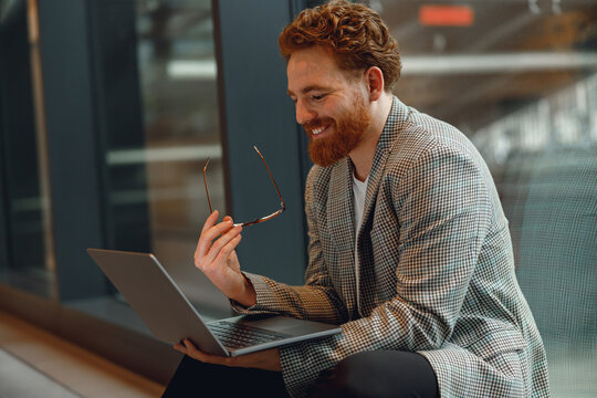Male freelancer have a videoconference with colleague while sitting in cozy coworking