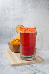 Michelada, Mexican beer drink with chamoy and clamato, with french fries on a white background without people