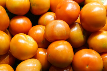 Close-up view of fresh juicy tomatoes in a supermarket.