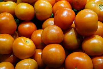 Close-up view of fresh juicy tomatoes in a supermarket.