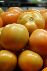 Close-up view of fresh juicy tomatoes in a supermarket.