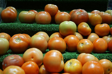 Close-up view of fresh juicy tomatoes in a supermarket.