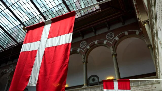 Interior of Copenhagen city hall with Danish flags hanging in Denmark. Low angle, tilt-up