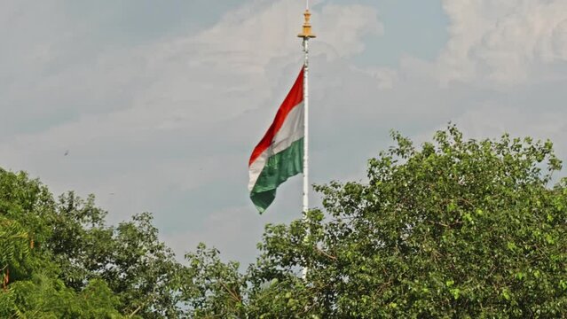 indian flag swaying with trees and clouds in the background daytime 4k 25p