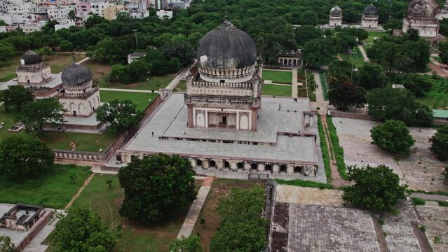 Qutub Shahi Tombs, hyderabad, telangana with crowded buildings and clouds at the background aerial establishing shot drone shot