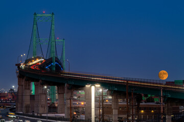 Long Exposure of the Vincent Thomas Bridge in San Pedro, Ca, with the Rising Full Super Moon at Golden Hour