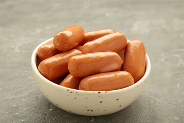 Chicken cocktail sausage on bowl on grey concrete background.