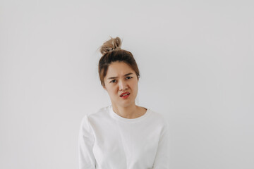 Asian Thai woman wear sweater bun hair, funny doubt and curious face, have question looking at camera, isolated on white background wall at winter.
