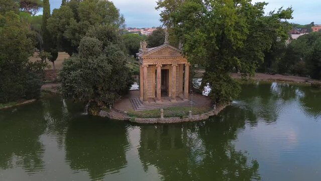 Temple of Aesculapius in Villa Borghese in Rome (capital of Italy). The construction is built on an artificial island of the villa's lake. Close orbital move.