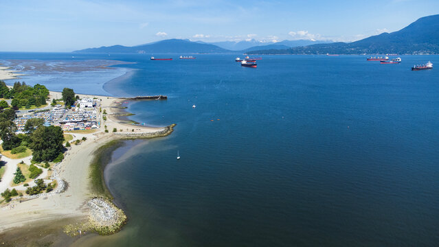 Aerial view of Burrard Inlet from Jericho Beach. West Vancouver in the background. Sandy beaches exposed by low tide. 