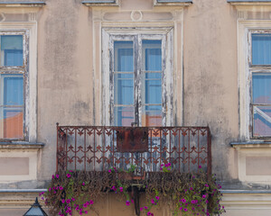 Fototapeta na wymiar View of an old balcony decorated with flowers at the King Tomislav Square, Samobor, Croatia
