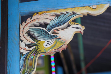 Wooden statues shaped like phoenixes are decorated on the roofs of ancient houses of An Giang people