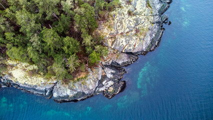 Top down view over Merry Island, Sunshine Coast. Trees cover the island right up to the shoreline....