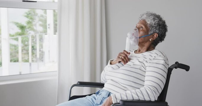 Senior african american woman in wheelchair with oxygen mask, copy space, slow motion