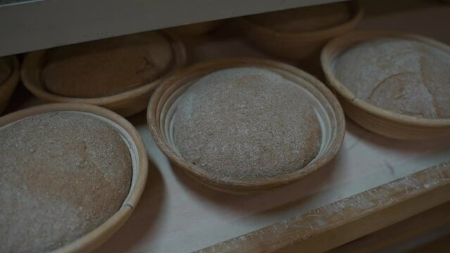 Bread dough blanks in old raffia baskets in a bakery