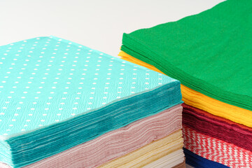Two stacks of colorful paper napkins on white background