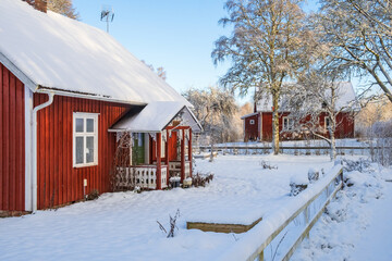 Idyllic red cottage with a porch in the winter
