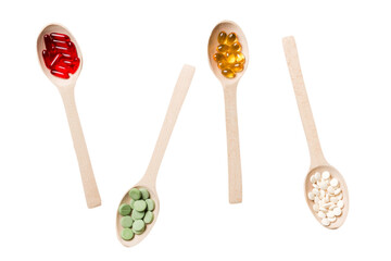 Top view Variety of vitamin and mineral pills in wooden spoon on Colored background. Top view of assorted pharmaceutical medicine pills. Dietary supplement healthcare product