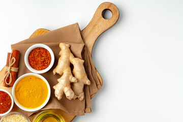 Ginger root and various spices on white background