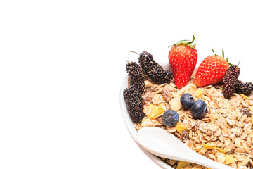 Top view of delicious breakfast bowl of corn flakes with strawberries, blueberries and mulberry
