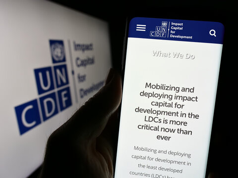 Stuttgart, Germany - 09-25-2023: Person holding cellphone with website of United Nations Capital Development Fund (UNCDF) in front of logo. Focus on center of phone display.