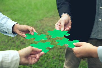 CSR, corporate social responsibility. The business team putting green jigsaw for the team together. Charity, volunteer. Unity, Environmental CSR Corporate social responsibility concept. ESG