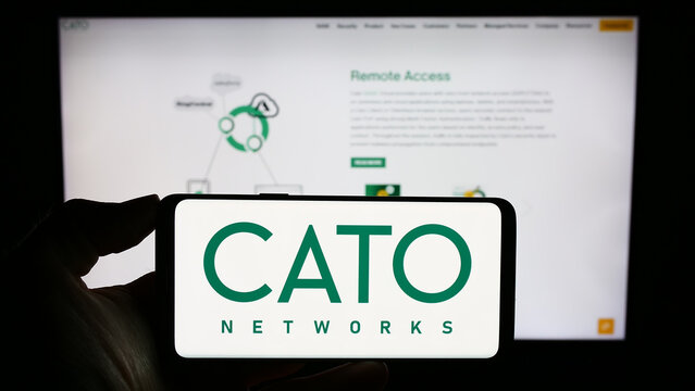 Stuttgart, Germany - 09-27-2023: Person holding cellphone with logo of Israeli network security company Cato Networks Ltd. in front of business webpage. Focus on phone display.