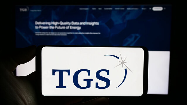 Stuttgart, Germany - 09-28-2023: Person holding cellphone with logo of analytics business TGS-NOPEC Geophysical Company ASA in front of business webpage. Focus on phone display.