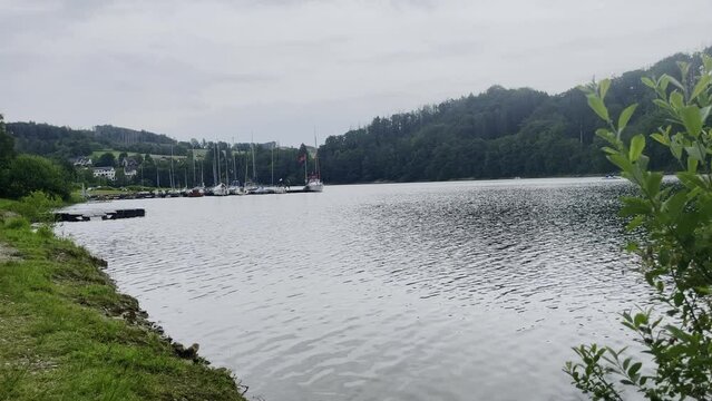 Ships and boats lie on a bank of the agger dam with a forest in the background