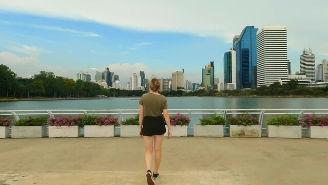 Parks And Recreation In Bangkok Thailand. Female Model Taking A Leisurely Walk In Benjakitti Park.