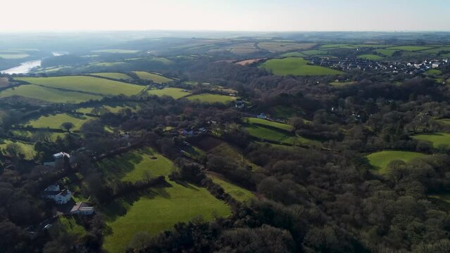 Aerial footage over Cornish countryside showing the hilly landscape dotted with woods and fields