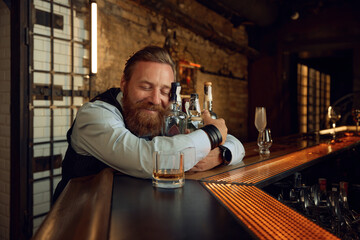 Portrait of drunk mature man hugging bottle with alcoholic beverage