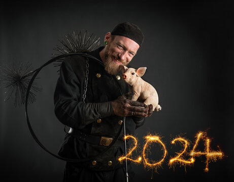 Schornsteinfeger, Glücksschwein und Jahreszahlen 2024 mit Wunderkerzen geschrieben. Drei Glücksbringer für das Neue Jahr 2024.