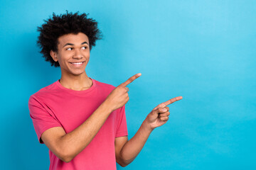 Photo of positive satisfied man wear pink trendy clothes two arms presenting empty space isolated on blue color background