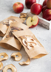 Packages of assorted sweet dried apple chips and slices on light background.Macro.