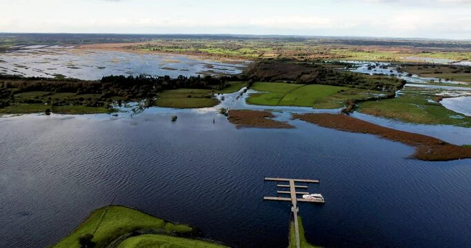A 4K dropping drone reveal of the rath at Clonmacnoise on the River Shannon in flood Co Offaly Ireland