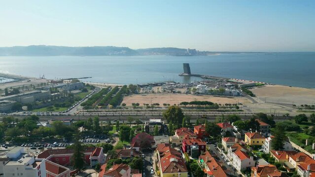 Flying backwards Alges cityscape with The Centre for Coordination and Control of Maritime Traffic and Safety, installed in the VTS Tower as background,Oeiras,Portugal