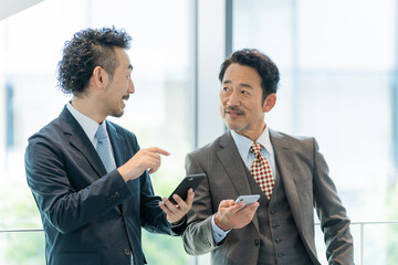 スマホを見せるビジネスマンたち
