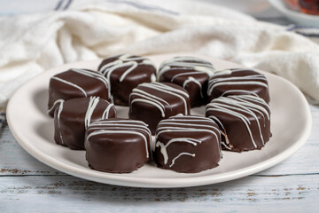 Chocolate cookie. Delicious cookies with coconut inside and chocolate outside on a wooden background. patisserie products. Close up