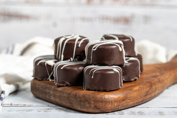 Chocolate cookie. Delicious cookies with coconut inside and chocolate outside on a wooden background. patisserie products. Close up