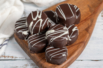 Chocolate cookie. Delicious cookies with coconut inside and chocolate outside on a wooden background. patisserie products