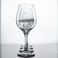 Glass wine glasses in reverse light. Crystal wine glasses with water drops