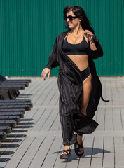 A woman runs in a black swimsuit