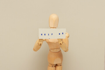 A wooden mannequin holds a card with the words help me, a call to wince. - obrazy, fototapety, plakaty