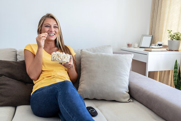 Cropped shot of an attractive young woman sitting in her living room and watching a movie during a day off.