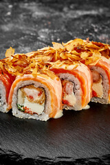 Sushi roll with salmon, shrimp and cream cheese on a concrete background