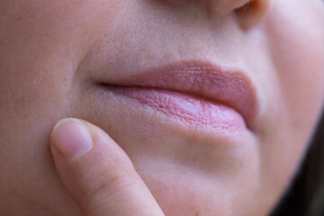 close up lips of mature female face, woman 50 years old carefully examines wrinkles around mouth, skin defects, facial hair, age-related changes, aesthetic cosmetology, anti-aging procedures