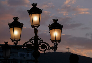 Streetlights in Skopje, North Macedonia, against a dramatic evening sky - obrazy, fototapety, plakaty